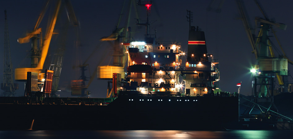 Cargo vessel operating at night in port